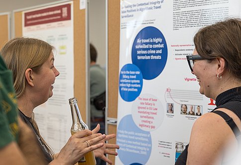 Two women discuss a scientific poster