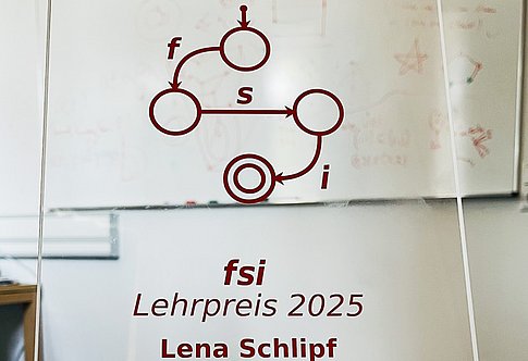 an acrylic glass stand with the logo of Fachschaft Informatik and the writing 'fsi Lehrpreis 2025 - Lena Schlipf' on it (photo: Lena Schlipf)